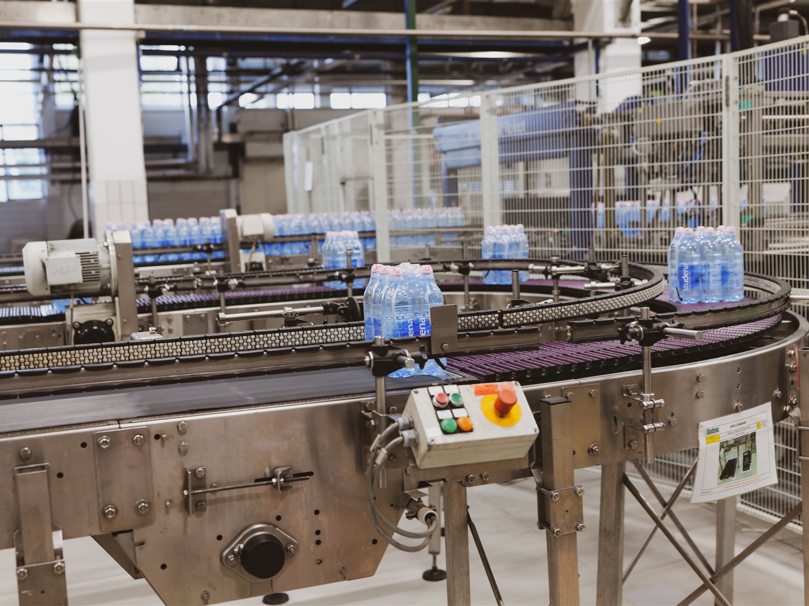 Línea de embotellado con transportadores en una planta